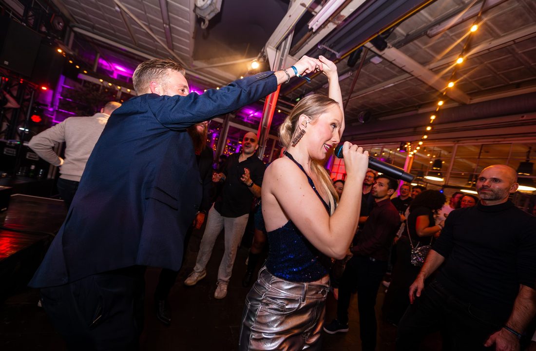 Zangeres treedt tussen de dansende gasten op tijdens een feest