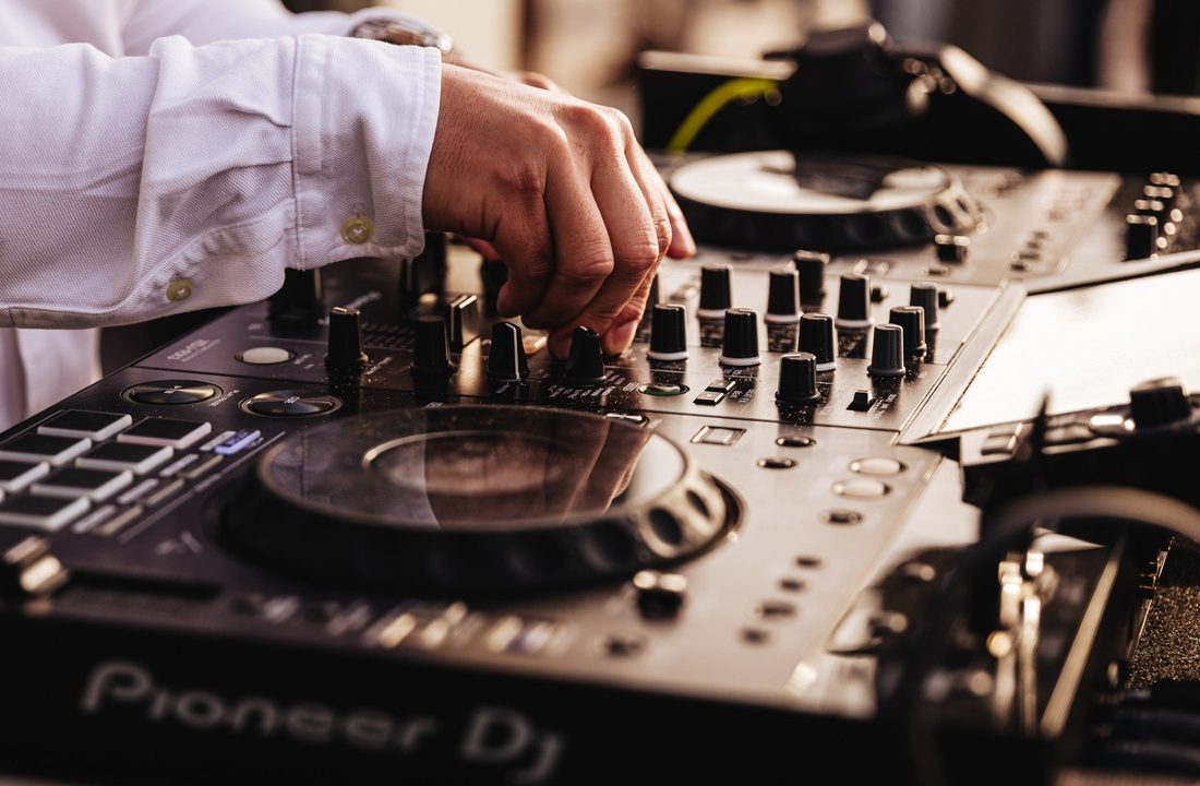 Hand van een DJ aan de knoppen van professionele DJ-apparatuur