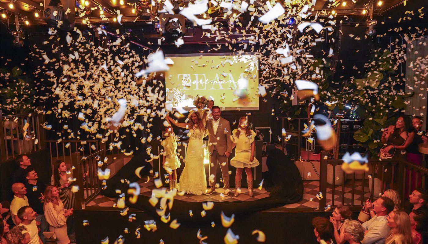Bruidspaar en kinderen tussen de confetti tijdens een feestelijke bruiloft