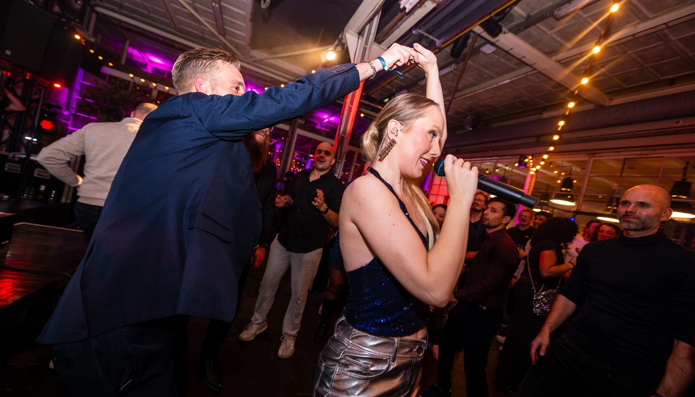 Zangeres treedt tussen de dansende gasten op tijdens een feest