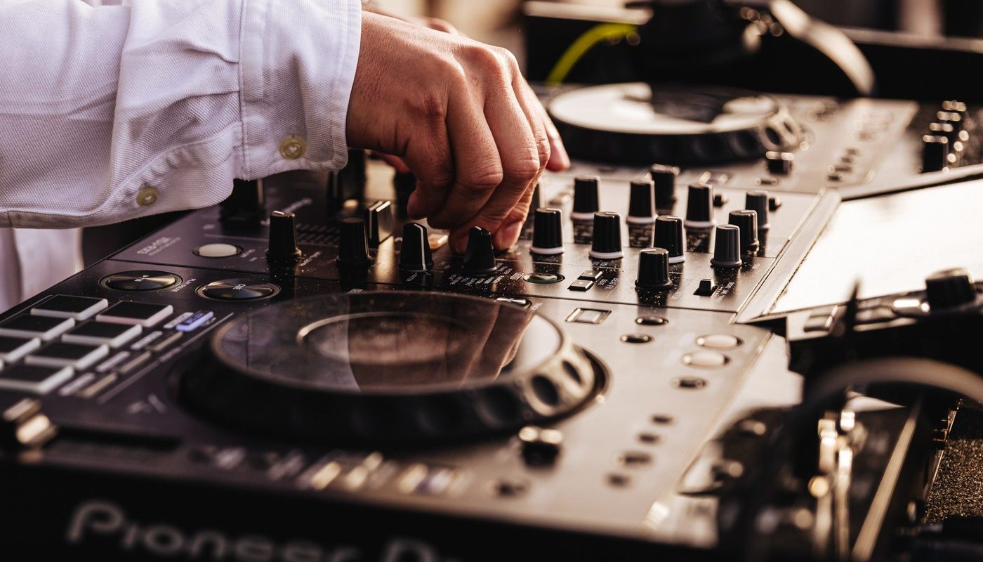 Hand van een DJ aan de knoppen van professionele DJ-apparatuur